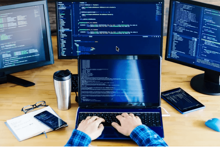 Developer workstation with multiple monitors building custom SaaS and mobile software